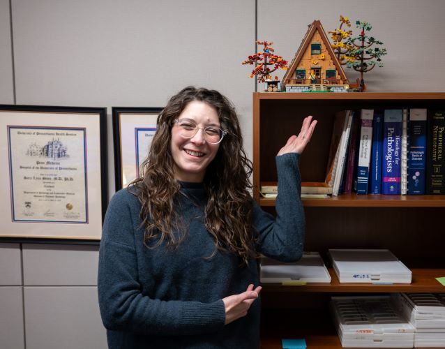 Dr. Sara Stone poses with her Lego birdhouse, reflecting her love for crafts.